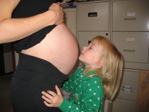 Claudia kissing baby belly